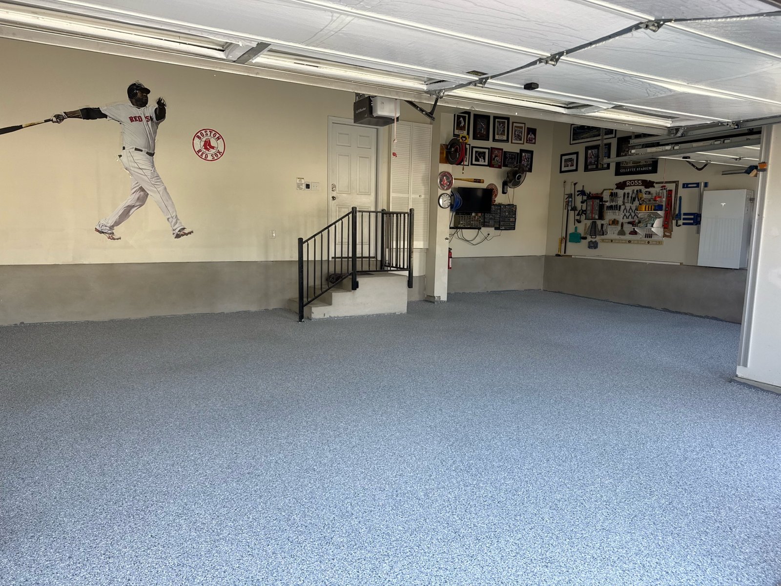 Blue-gray flake-style garage floor with baseball player mural in Austin, Texas